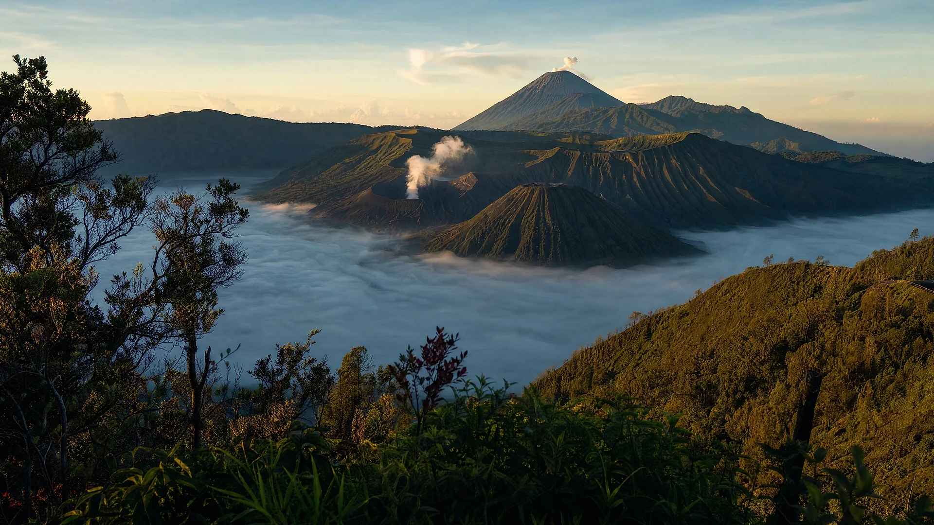 A Javanese volcanic caldera above a sea of cloud at sunrise