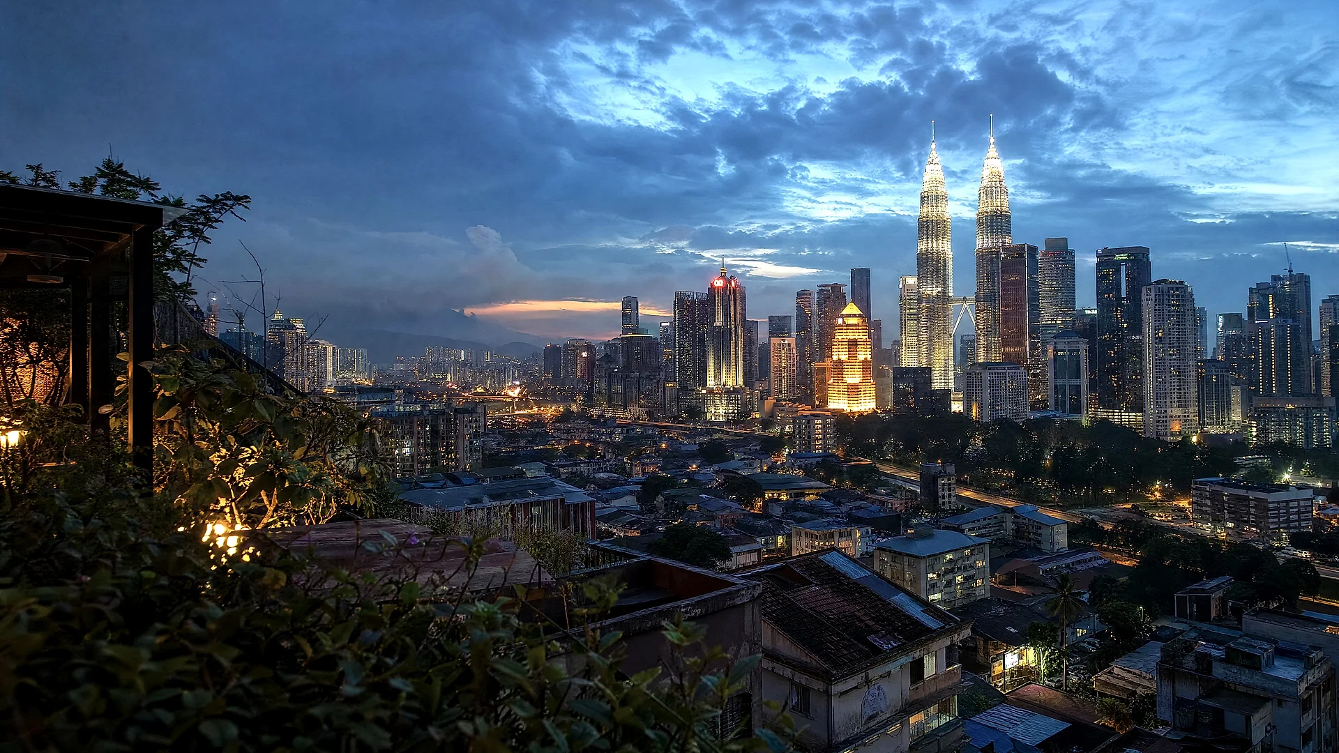 The Kuala Lumpur skyline at blue hour, the Petronas Towers lit above the city